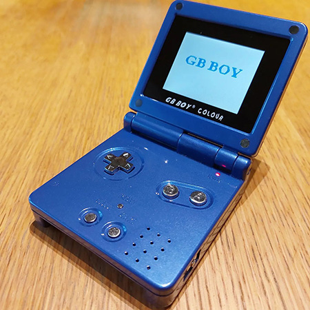 photo of a game boy clone shaped like a blue game boy advance SP: the GB Colour