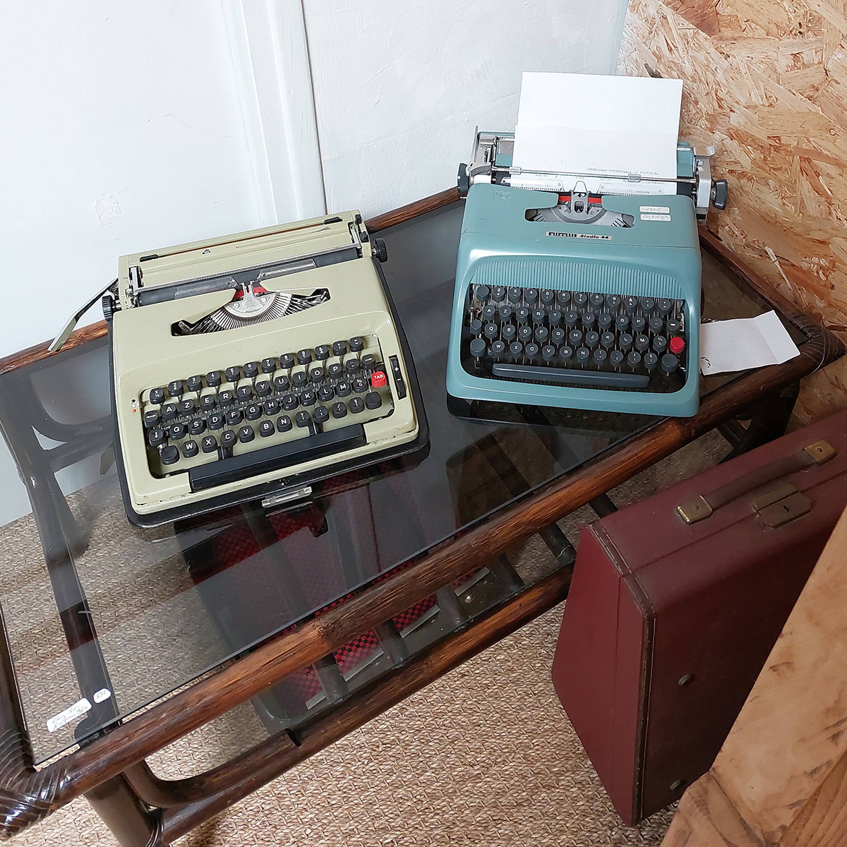 2 typewriters side by side on a small table